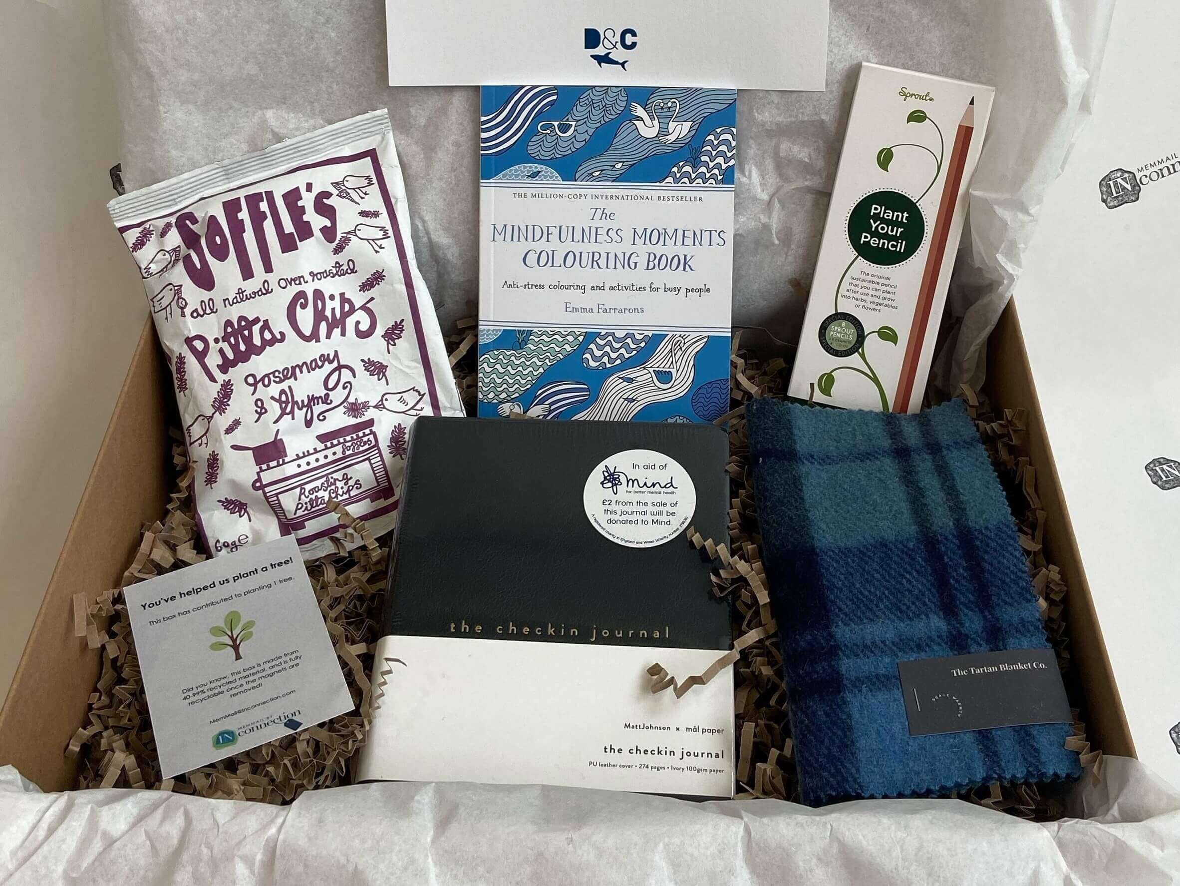 A gift hamper filled with ecofriendly products with a note that reads 'You've helped us plant a tree'